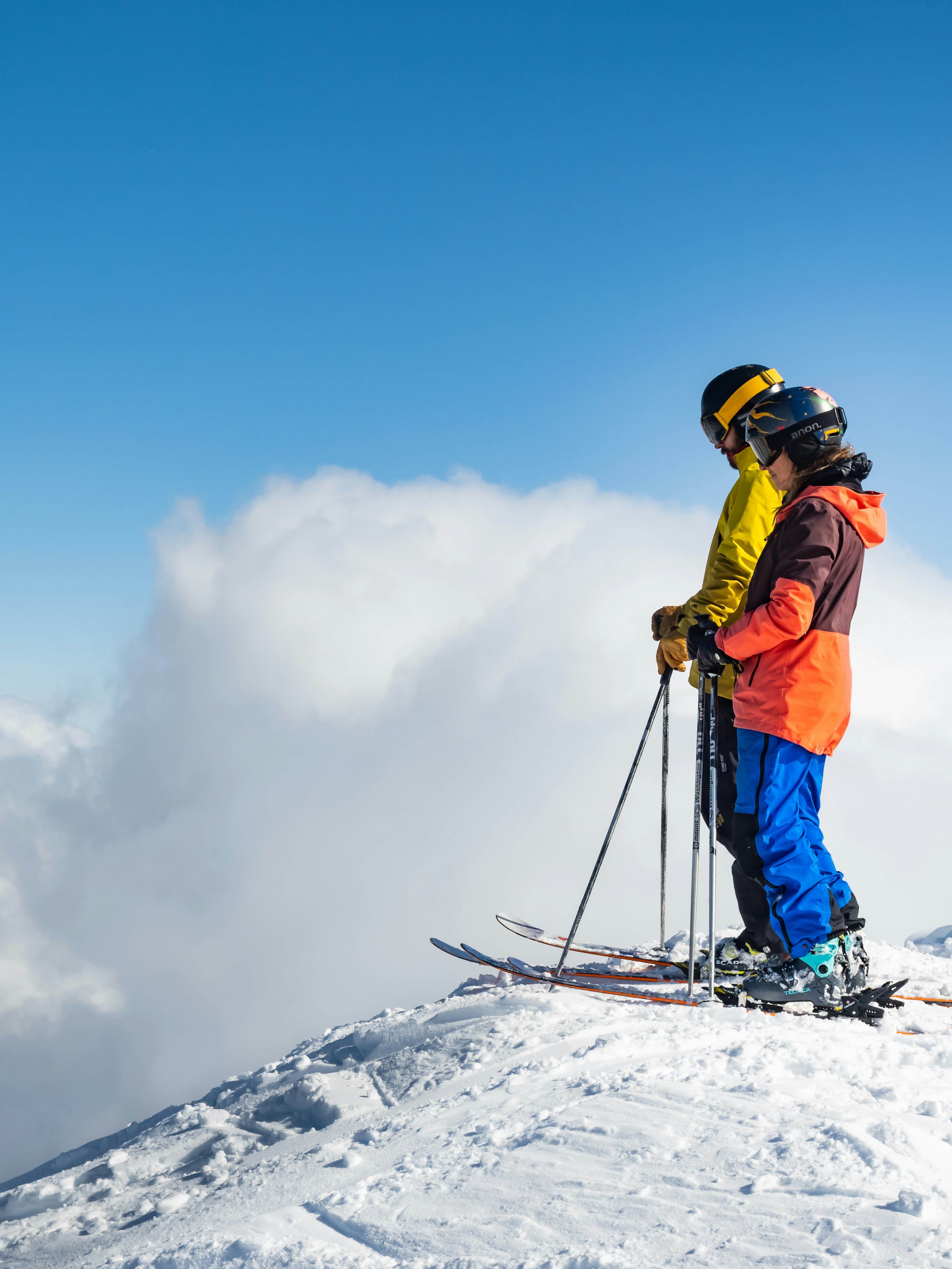 Deux skieurs au sommet du domaine, au-dessus des nuages